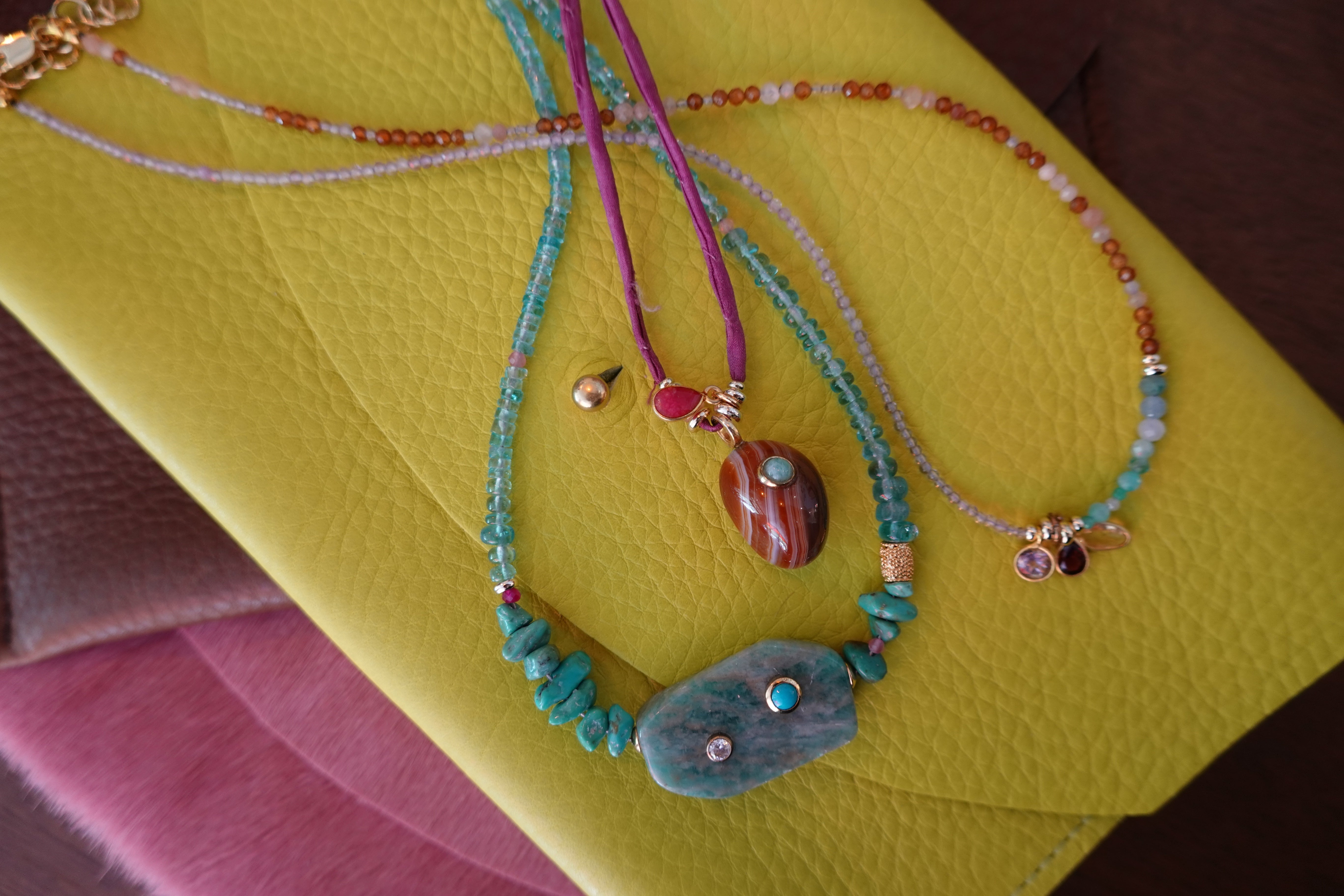 Colorful beaded necklaces on a yellow surface